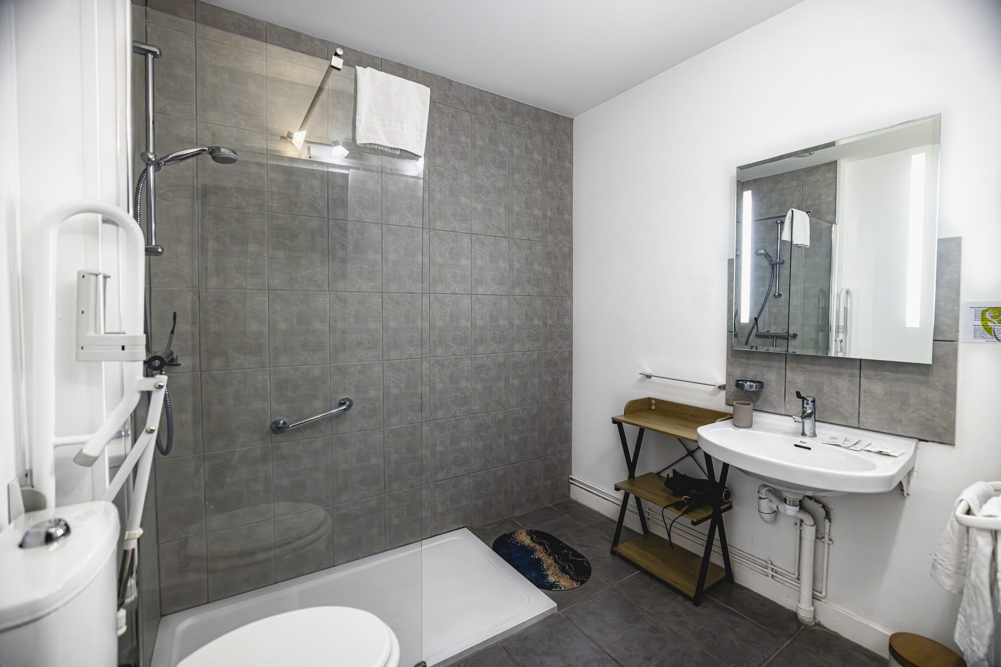 Sa salle de bain, douche à l'italienne et barres d'appui